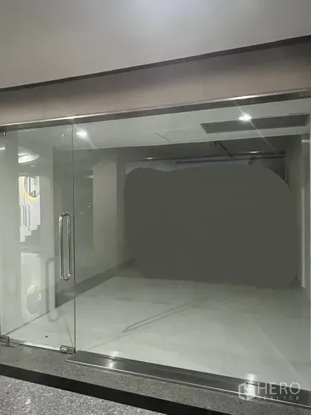 Retail Space for rent in Khlong Toei, Bangkok - Empty 31 sqm retail unit with full-height glass frontage, double glass doors, bright tiled interior and recessed ceiling lights near BTS Thong Lo.