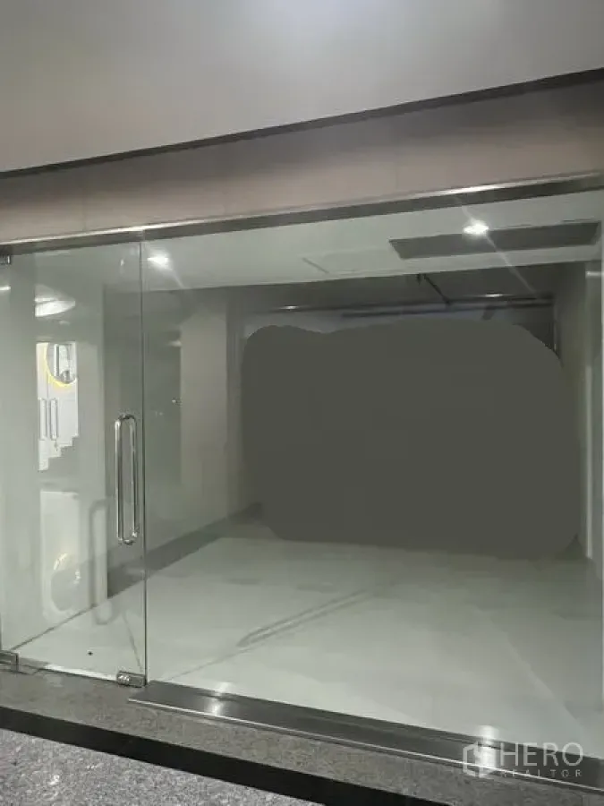 Retail Space for rent in Khlong Toei, Bangkok - Empty 31 sqm retail unit with full-height glass frontage, double glass doors, bright tiled interior and recessed ceiling lights near BTS Thong Lo.