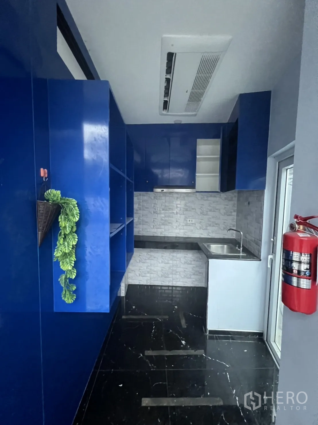 Retail Space for rent in Khlong Toei, Bangkok - Back pantry with blue cabinetry, sink and ceiling air-conditioning—ideal for café prep.