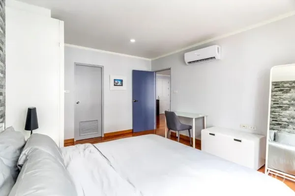 公寓 出租在Watthana, Bangkok - 带空调的卧室，设书桌、木地板与多扇门。