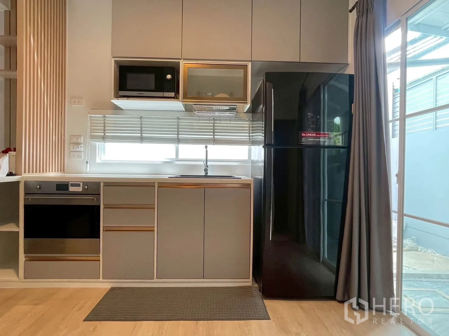 Townhouse for rent in Bang Phli, Samut Prakan - Modern kitchen with fridge, microwave, oven and window.