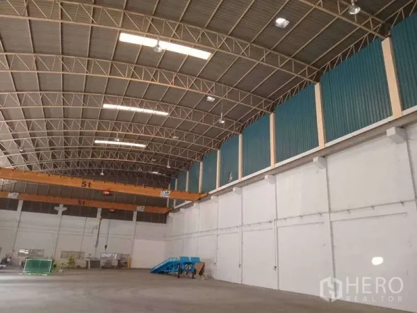 Factory for rent in Mueang Samut Prakan, Samut Prakan - Spacious factory hall featuring a 5-ton overhead crane beneath an arched steel truss roof.
