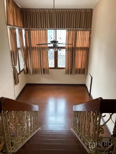 独立式住宅 出租在Khlong Toei, Bangkok - 楼梯平台配高窗与窗帘及吊扇，自然采光充足。