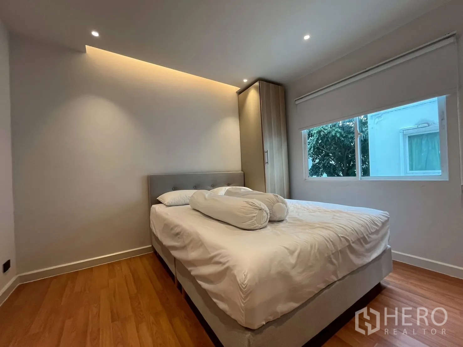 联排别墅 出租在Prawet, Bangkok - 极简卧室，宽窗、衣柜与温暖灯带
