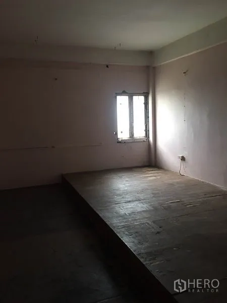 Shophouse for rent in Khlong Toei, Bangkok - Upper-floor room with a raised platform stage and a single window.