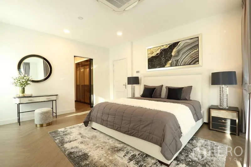 Detached House for rent in Saphan Sung, Bangkok - Master bedroom with vanity table, twin lamps and doorway to a walk-in closet.