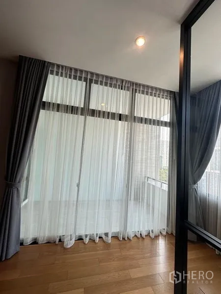 联排别墅 出售在Saphan Sung, Bangkok - 落地窗配纱帘，通向小阳台的空间。