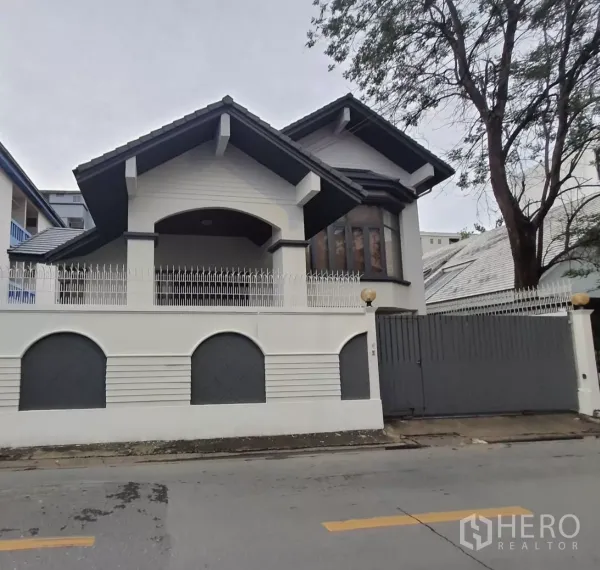 带办公室的家 出租或出售在Chatuchak, Bangkok - 乍都节安静街区的白色外立面住办两用房，尖顶屋檐与围墙大门。