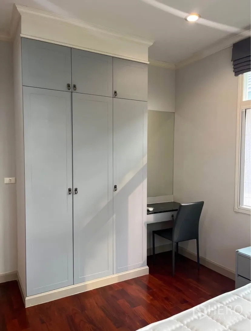 Detached House for rent or sale in Lat Phrao, Bangkok - Built-in wardrobe with vanity corner in a bright bedroom.