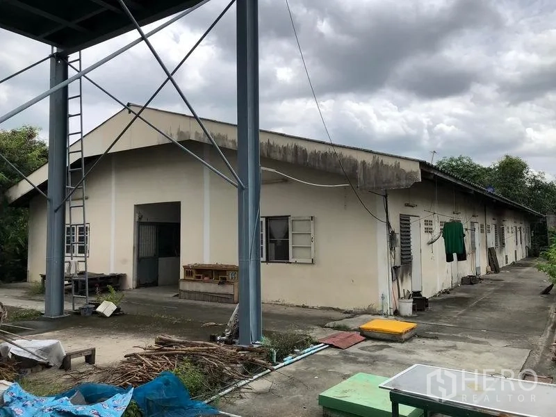 Factory for rent or sale in Lam Luk Ka, Pathum Thani - Single-storey worker dormitory building beside the factory yard.