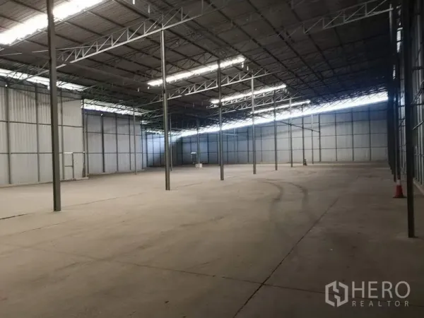 Warehouse for rent in Pak Kret, Nonthaburi - Open‑plan storage hall with multiple steel columns and smooth concrete flooring.