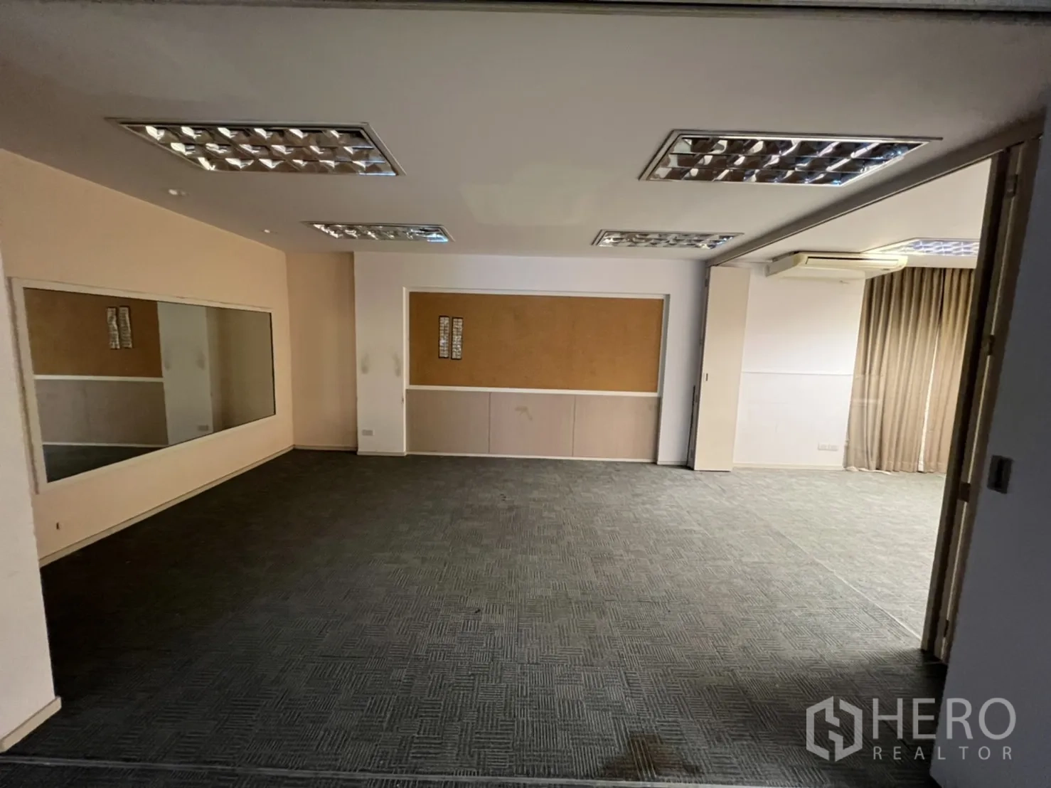 Shophouse for rent or sale in Watthana, Bangkok - Large training room with carpet tiles and a wall-sized mirror.