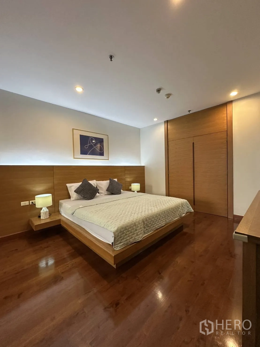 公寓 for rent in Watthana, Bangkok - 主卧室配木地板、双人床与暖色灯光。