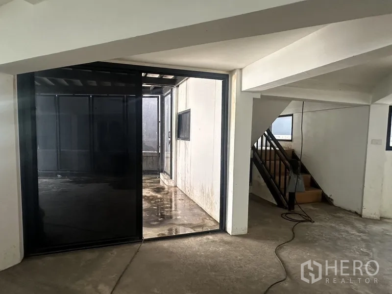 Home Office for rent or sale in Bang Na, Bangkok - Interior view toward a small courtyard and staircase with metal handrail.