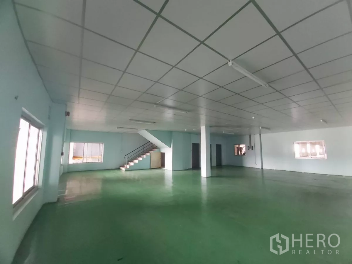 Warehouse for rent in Bang Bo, Samut Prakan - Large admin area with green flooring and wide windows for light and ventilation.