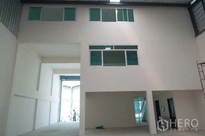 Factory for rent in Bang Sao Thong, Samut Prakan - Interior view showing warehouse entrance and multi-level office windows.
