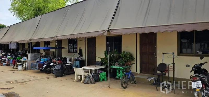 คลังสินค้า ให้เช่าในBang Kruai, Nonthaburi - แถวห้องพักพนักงานใต้กันสาดยาว มีรถจักรยานยนต์และต้นไม้หน้าห้อง