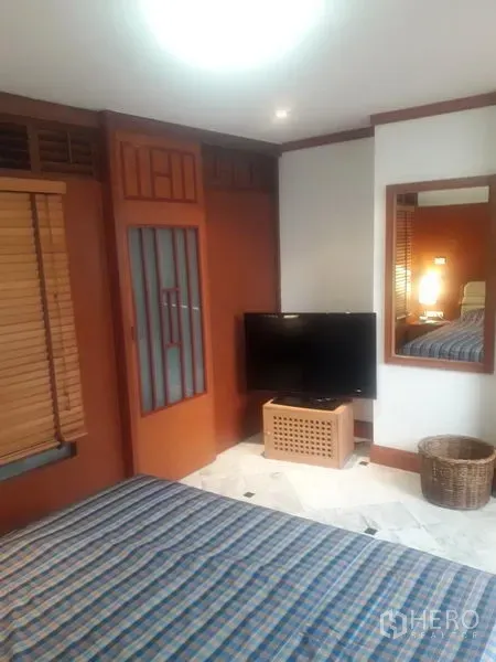 公寓 出租在Watthana, Bangkok - 卧室一角有电视、墙面镜、木框衣柜门和大理石地面