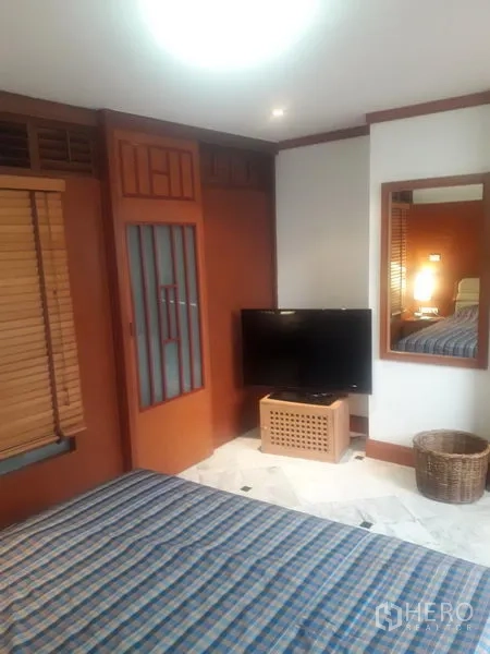 公寓 出租在Watthana, Bangkok - 卧室一角有电视、墙面镜、木框衣柜门和大理石地面