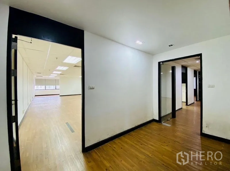 办公空间 出租或出售在Watthana, Bangkok - 入口前厅连接多间房间，木地板与玻璃门的现代办公室。
