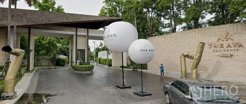 Detached House for sale in Suan Luang, Bangkok - Gated entrance to a secure residential compound with landscaped driveway.