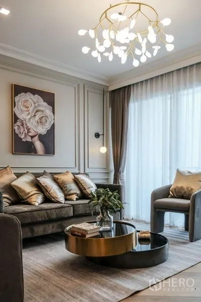 Condominium for rent in Khlong Luang, Pathum Thani - Bright lounge with floor-to-ceiling curtains, round coffee table and chandelier.