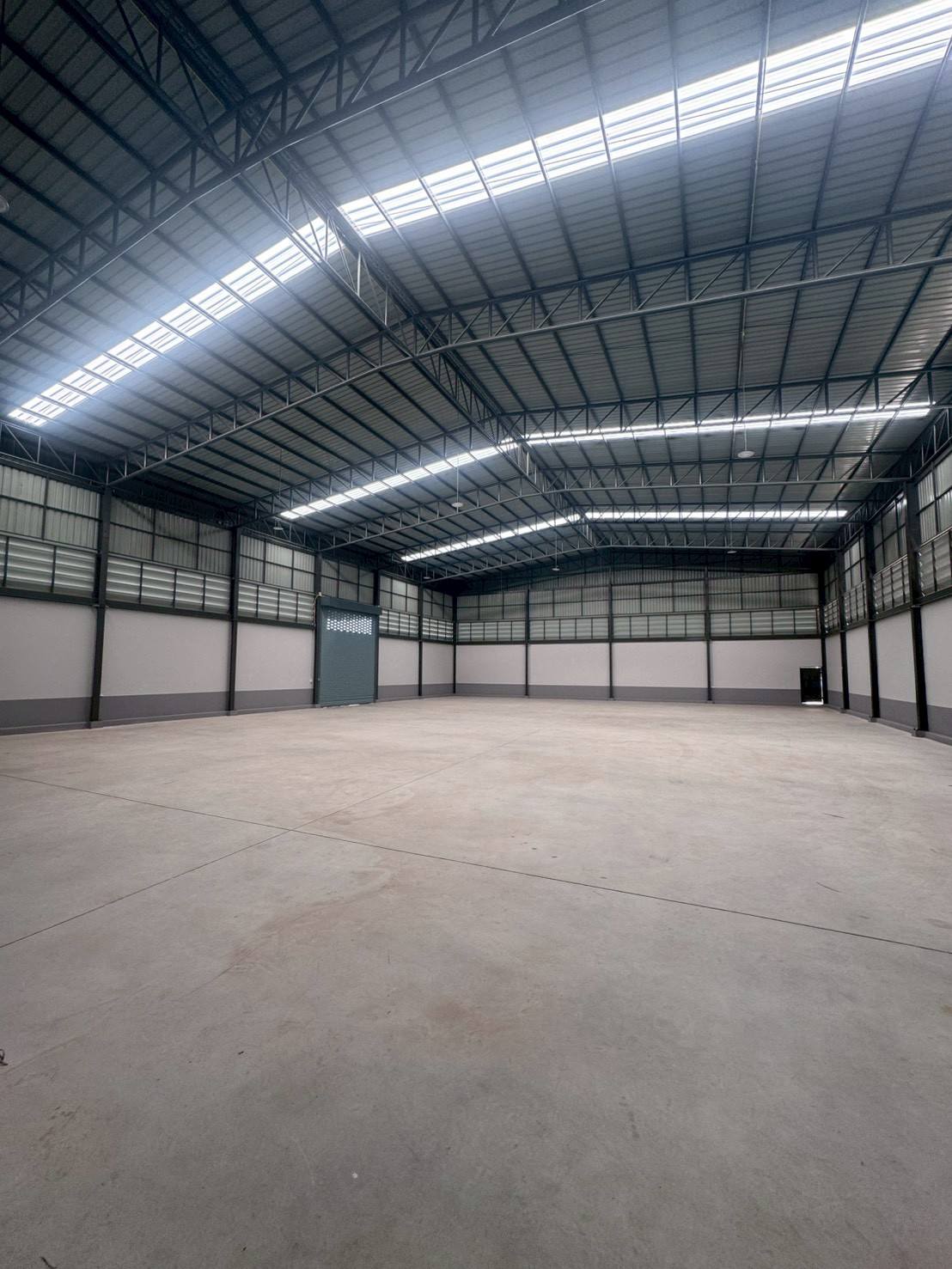 โรงงาน ขายในMueang Samut Sakhon, Samut Sakhon - พื้นโกดังโล่ง หลังคาทรงโค้งมีแผ่นช่องแสง และประตูม้วนกว้าง