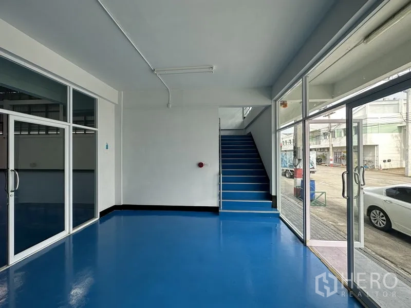 Factory for rent in Khlong Luang, Pathum Thani - Ground‑floor reception area with glass sliding doors and staircase to upper offices.