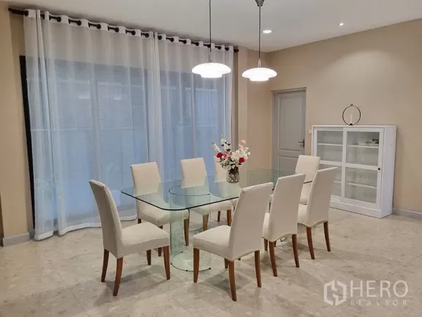 Detached House for rent in Bang Khae, Bangkok - Close view of the dining area with a glass-top table and six cream chairs under soft downlights.