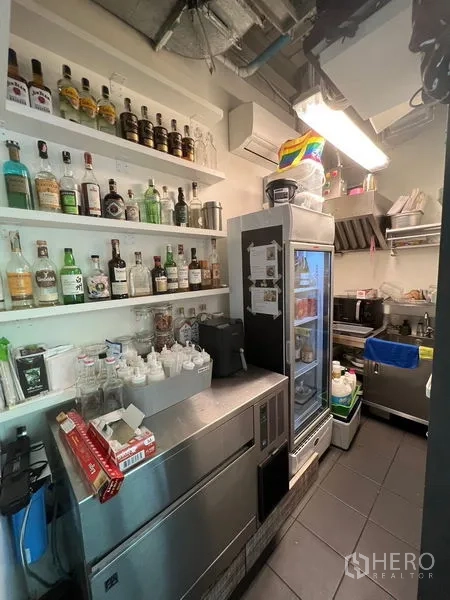 Retail Space for rent in Khlong Toei, Bangkok - Compact back‑of‑house with shelving, refrigerators, and bar supplies neatly arranged.