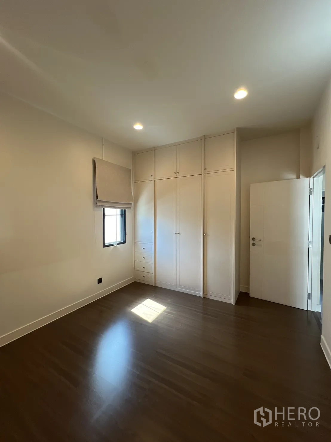 Detached House for sale in Bang Kapi, Bangkok - Bedroom with built-in wardrobes by the door and wood floors.