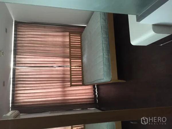 公寓 出租在Ratchathewi, Bangkok - 卧室采光良好，木质床架、落地窗帘与深色木地板的曼谷公寓。