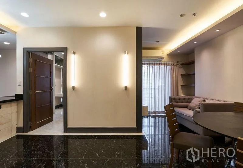คอนโด ขายในRatchathewi, Bangkok - ห้องนั่งเล่นกะทัดรัดพร้อมผนังทีวี โซฟา และม่านโปร่งเปิดสู่ระเบียง