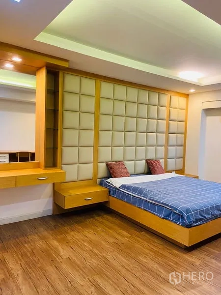 คอนโด ให้เช่าในWatthana, Bangkok - ห้องนอนหลักมีหัวเตียงบุหนังแบบแพดดิ้ง ชั้นบิลท์อินข้างเตียง และพื้นไม้โทนอุ่น