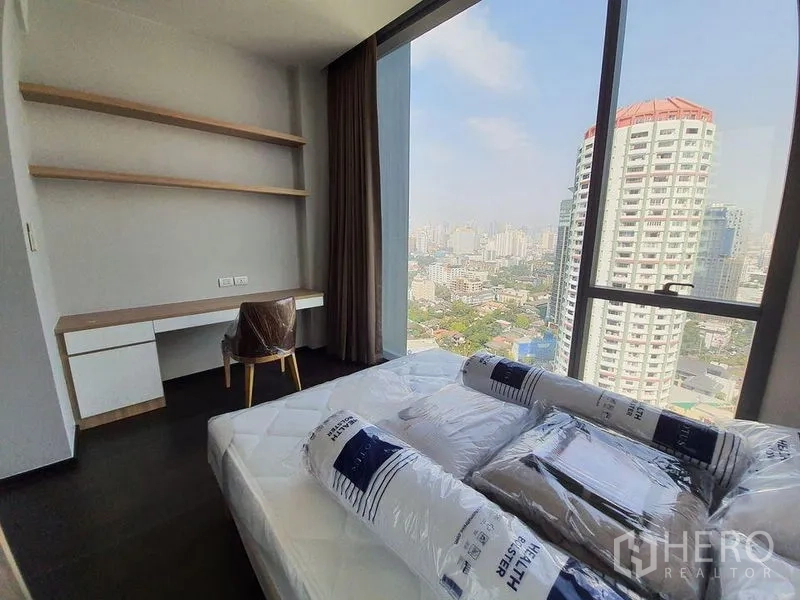 公寓 出租在Watthana, Bangkok - 带书桌与置物架的卧室，观赏城市天际线