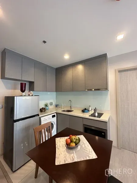 公寓 出租或出售在Khlong Toei, Bangkok - 现代厨房，灰色橱柜、冰箱、电磁炉、水槽和洗衣机。