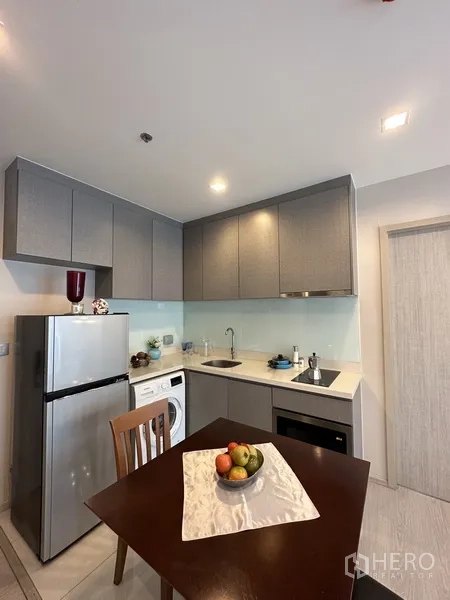 公寓 出租或出售在Khlong Toei, Bangkok - 现代厨房，灰色橱柜、冰箱、电磁炉、水槽和洗衣机。