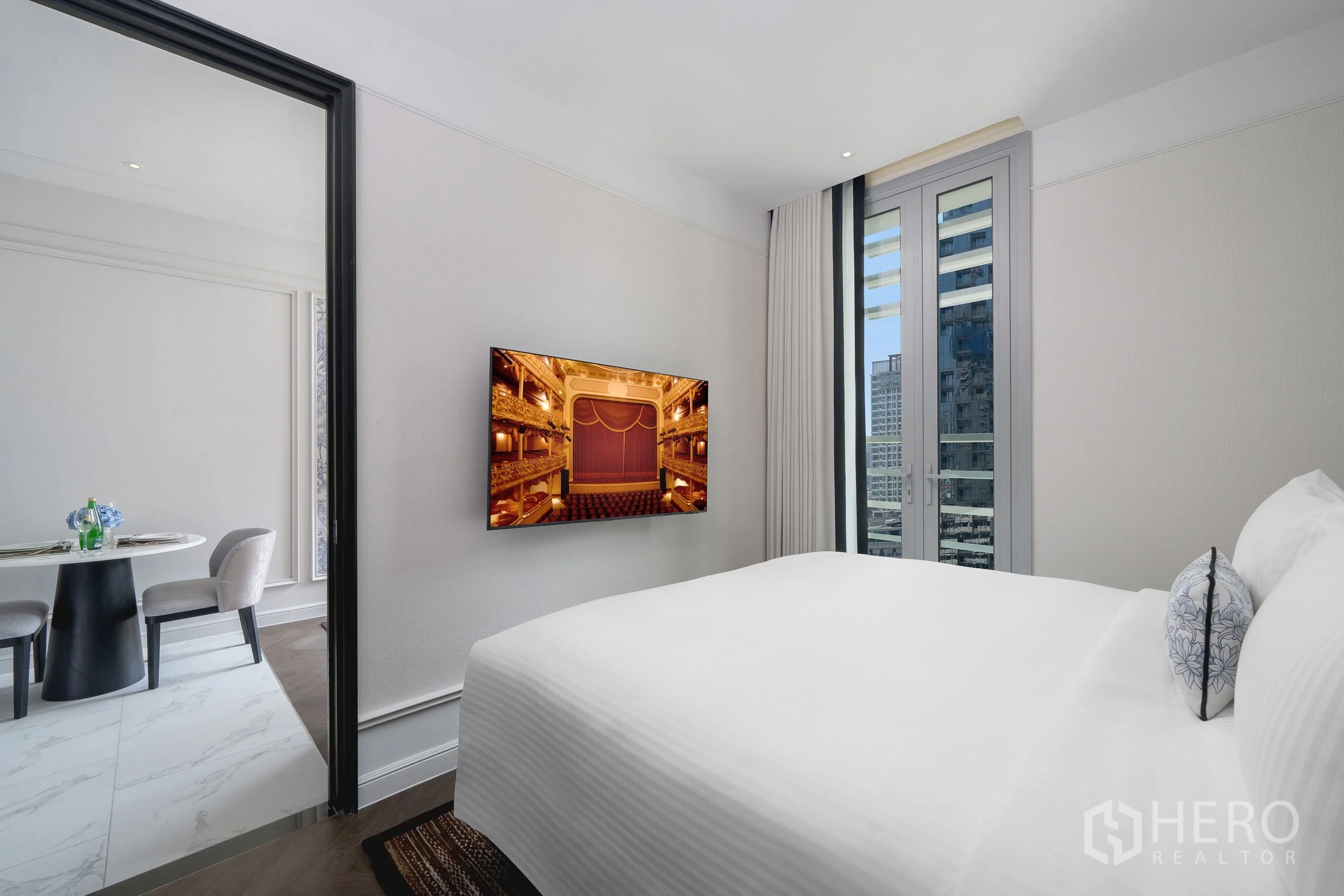 คอนโด for rent in Khlong Toei, Bangkok - ห้องนอนสว่างพร้อมเตียงใหญ่ ทีวีติดผนัง และหน้าต่างชมวิวเมือง