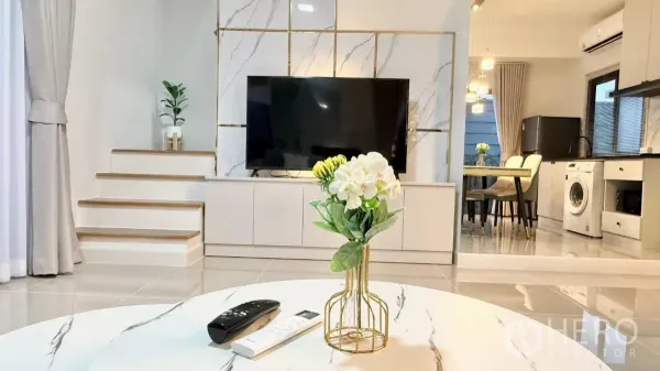 Townhouse for rent in Bang Phli, Samut Prakan - Built-in TV wall with marble finish and short stairway beside the living room.