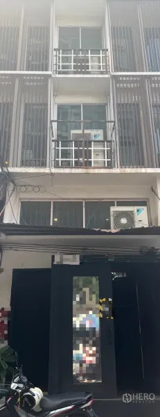 店屋 出租在Khlong Toei, Bangkok - 临街多层商铺房外立面，带阳台、推拉窗、竖向格栅及室外空调机组