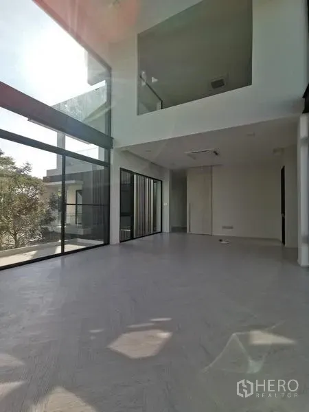 Detached House for rent or sale in Saphan Sung, Bangkok - Double-height living room with full-height glass walls flooding the space with natural light.