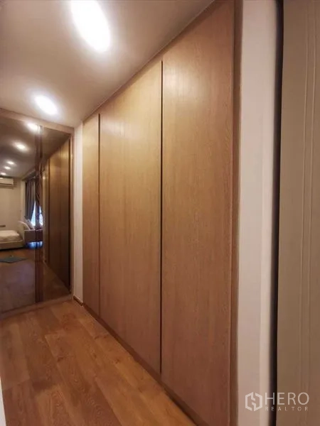 Condominium for rent in Ratchathewi, Bangkok - Built-in wardrobes along the hallway with a mirrored panel.