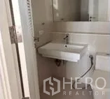 Condominium for rent in Watthana, Bangkok - Modern bathroom with large mirror, wall-mounted sink and toilet.
