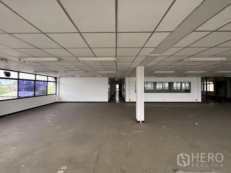Home Office for rent in Khan Na Yao, Bangkok - Open-plan office level with long window line, grid ceiling and partitioned rooms at the rear.