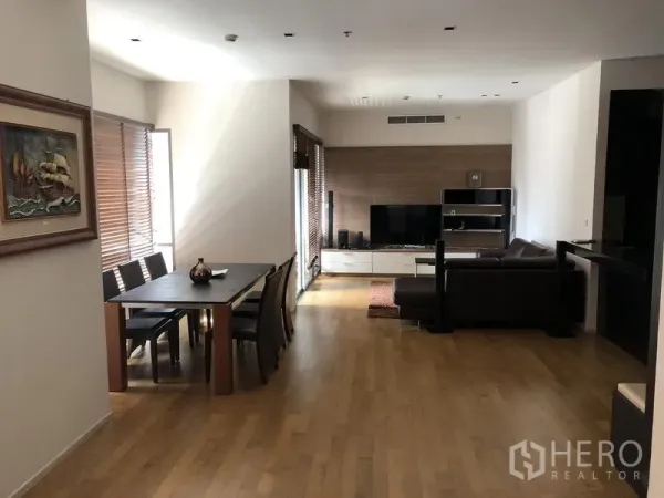 公寓 出租在Watthana, Bangkok - 开放式客餐厅，木地板、电视墙与L形沙发，位于The Madison，近Phrom Phong站。