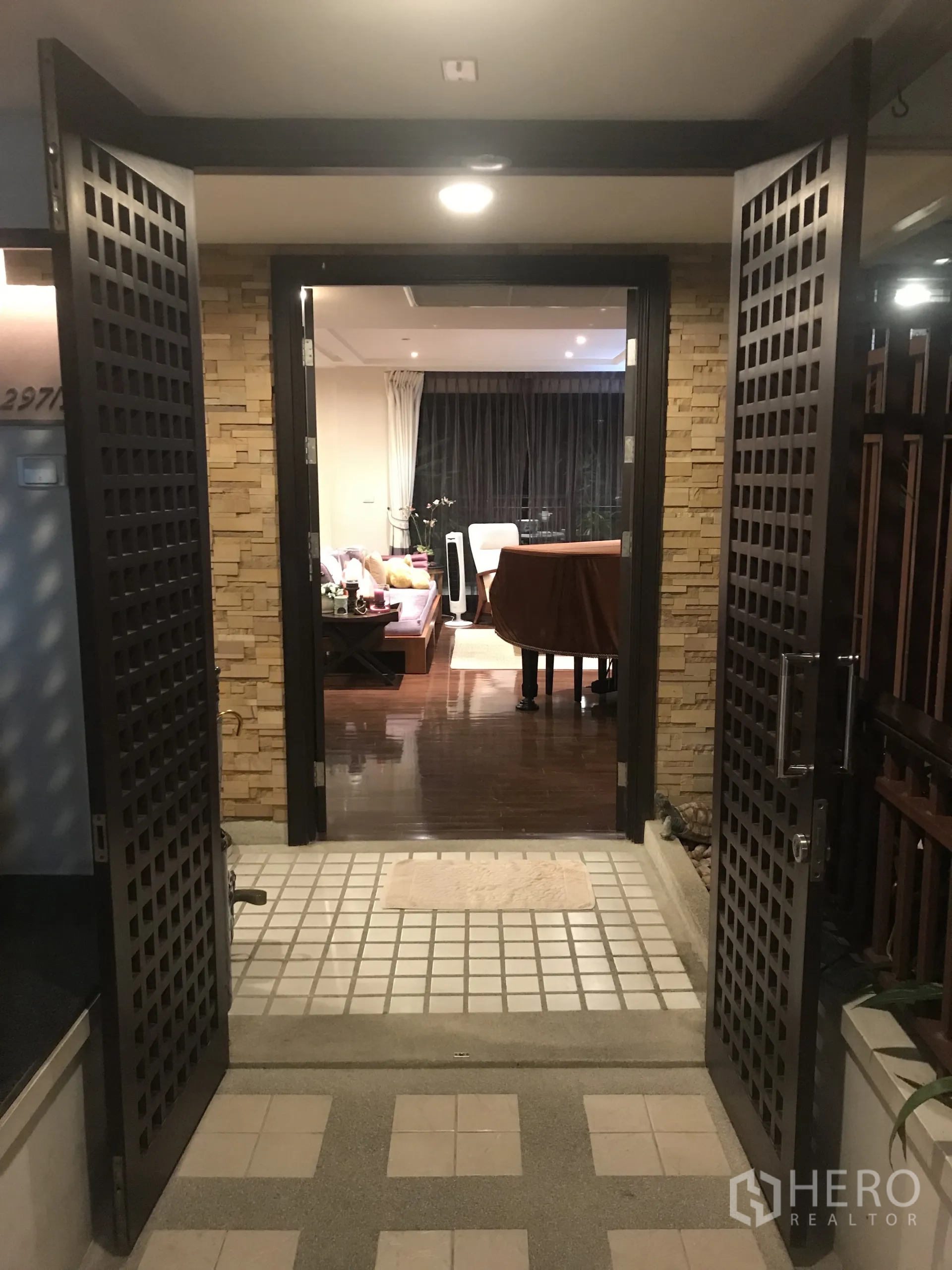 公寓 出售在Yan Nawa, Bangkok - 格栅双开入户门，通向木地板的温馨客厅。