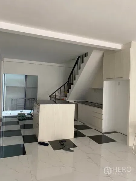 联排别墅 出租或出售在Khlong Toei, Bangkok - 开放式厨房与起居区，楼梯和中岛，黑白棋盘地砖