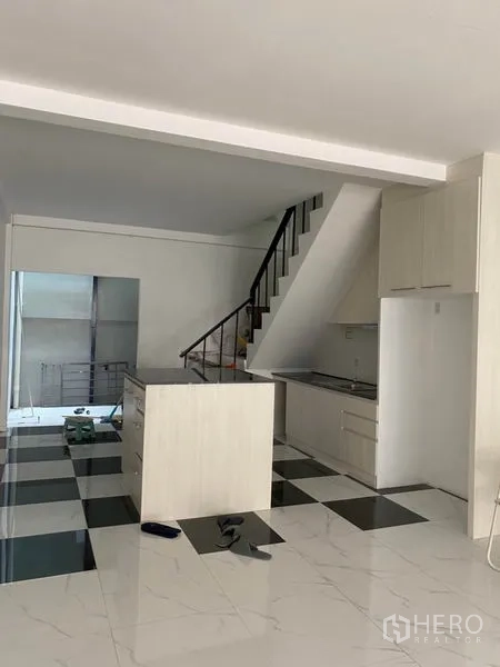 联排别墅 出租或出售在Khlong Toei, Bangkok - 开放式厨房与起居区，楼梯和中岛，黑白棋盘地砖