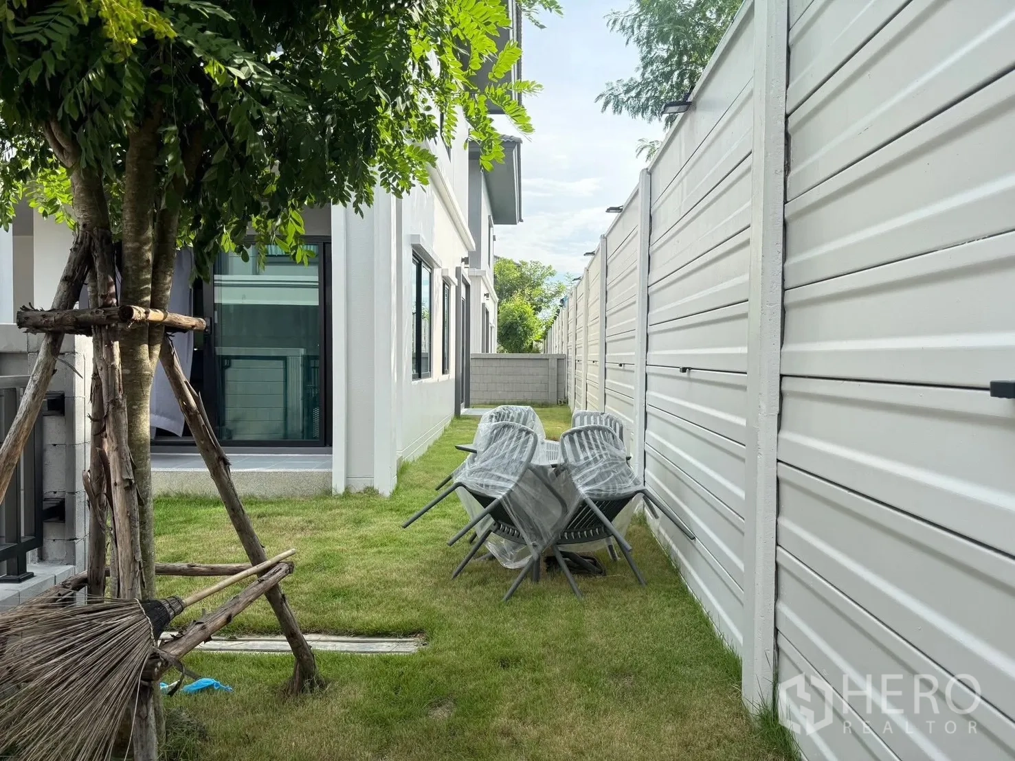 บ้านเดี่ยว for rent in Bang Phli, Samut Prakan - สนามหญ้าพร้อมต้นไม้ เก้าอี้กลางแจ้ง และประตูกระจกบานเลื่อน.
