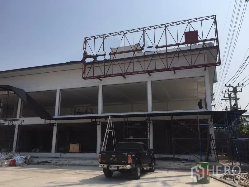 คลังสินค้า ให้เช่าในBang Kapi, Bangkok - มุมด้านหน้าของโกดัง มีโครงป้ายบนดาดฟ้า เพดานสูง และพื้นที่จอดรถ